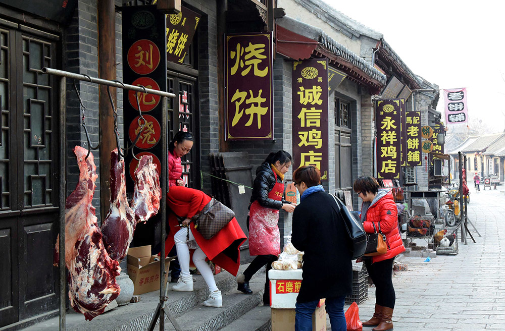 2015年2月2日，青州市市民在“修旧如旧”的东关街生活购物。新华社记者 徐速绘 摄