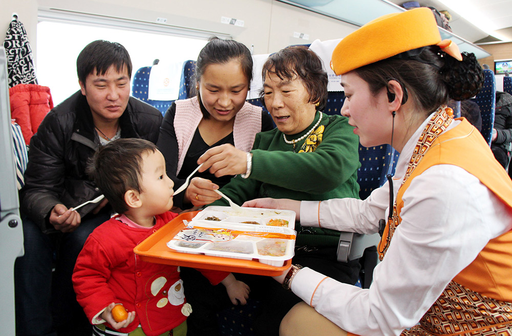 2015年2月3日，乘客在G232次列车上品尝平价套餐。新华社记者 朱峥 摄
