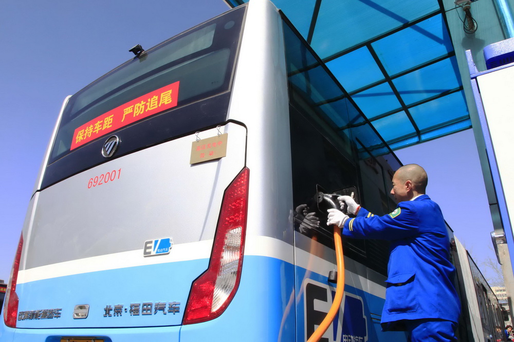 3月23日，工作人员在为18米纯电动公交车充电。新华社发