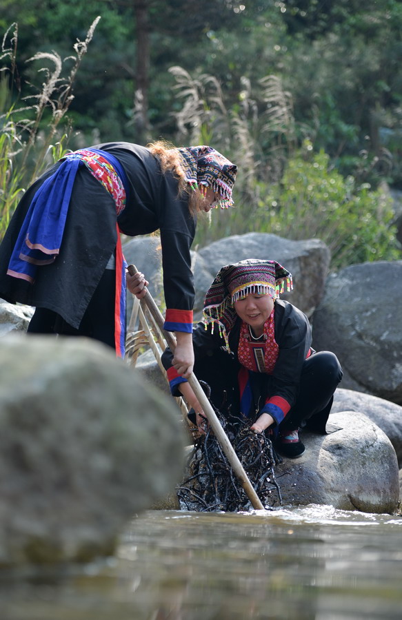 4月17日,郴州市宜章县莽山乡两名瑶族妇女在河边清洗蕨根.