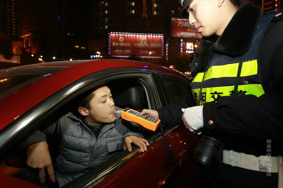 交警使用新型酒精探测仪,在街面上检查酒驾.