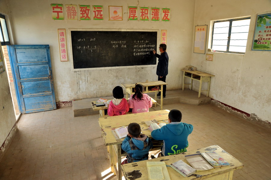 5月11日,甘肃环县甜水镇鲁掌村小学年届六旬的赵相儒老师在为混班的小