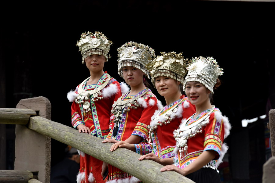 5月19日，在广西三江侗族自治县程阳八寨的风雨桥头，游客身着民族服饰拍照。 新华社发（吴练勋 摄）
