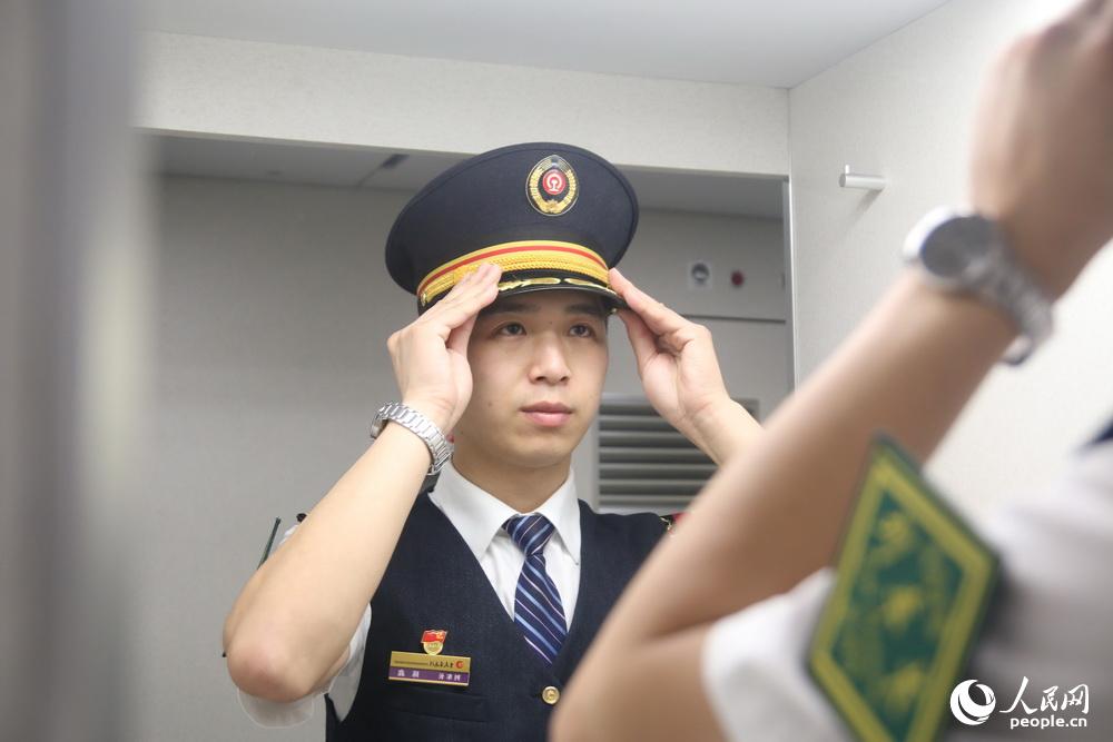 列车长陈鑫对着镜子着装