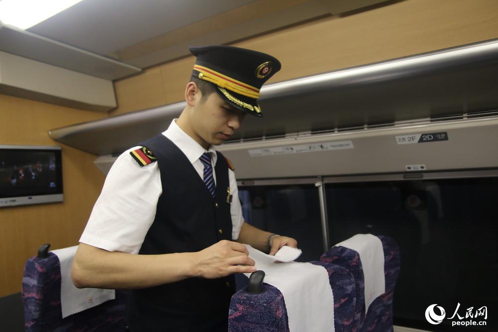 列车长陈鑫整理座椅。