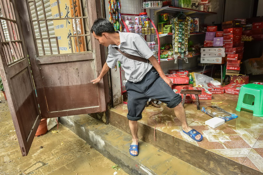 5月27日，雷山县城内一居民在介绍洪水最高时淹没的位置。 新华社记者 刘续 摄