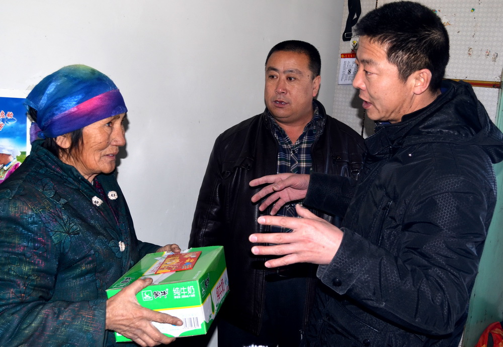 吉日嘎拉（右）在贫困牧民家慰问走访（2014年1月9日摄）。