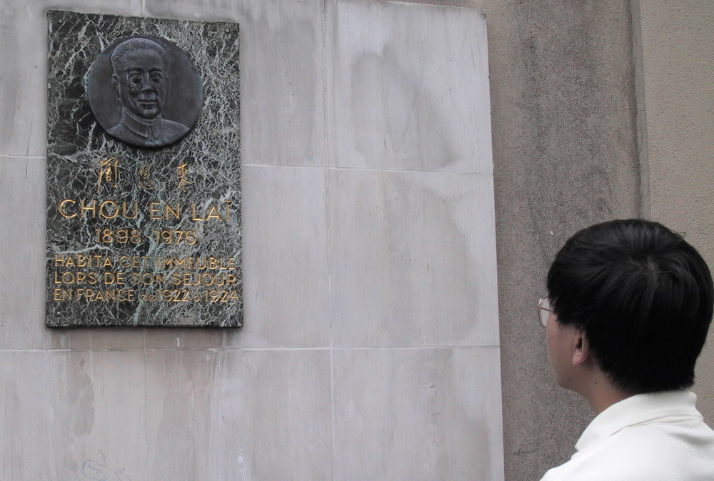 2001年6月27日，一名在巴黎工作的华人瞻仰镶嵌周恩来铜质头像的大理石纪念牌。周恩来1922年至1924年在巴黎勤工俭学和从事革命活动时就居住在这里――戈德弗鲁瓦街17号的小旅馆。这座纪念牌是法国政府于1979年10月设立的。 