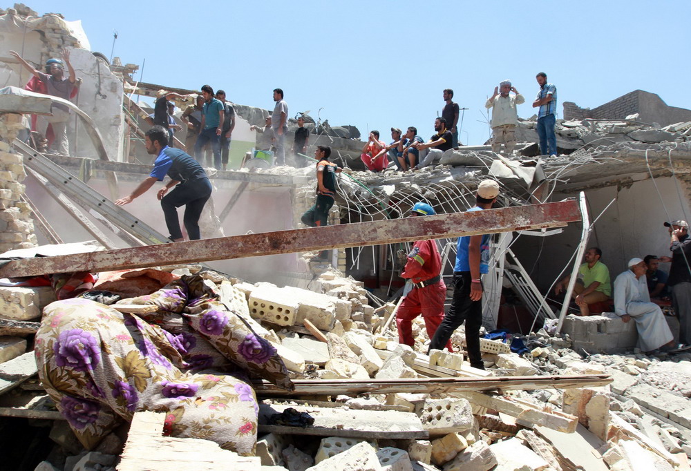 7月6日，在伊拉克首都巴格达的一处居民区，救援人员在废墟中搜寻幸存者。 