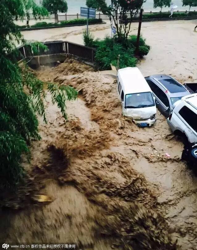 7月14日，巫溪县漫滩路上，山洪将停在路边的轿车冲入大宁河中（手机拍摄）。CFP 摄