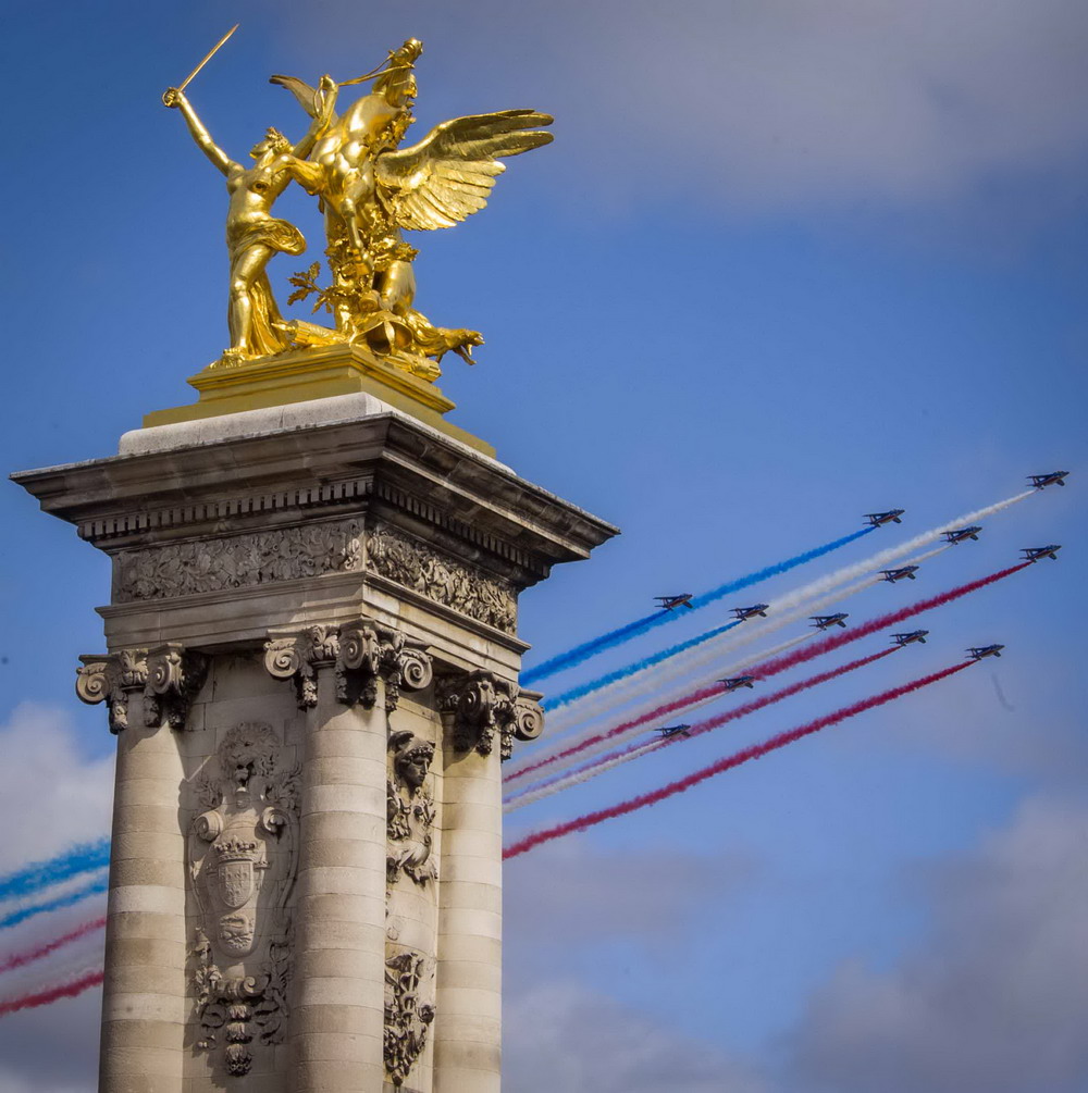 7月14日，在法国巴黎，法国空军飞机飞过亚历山大三世大桥。