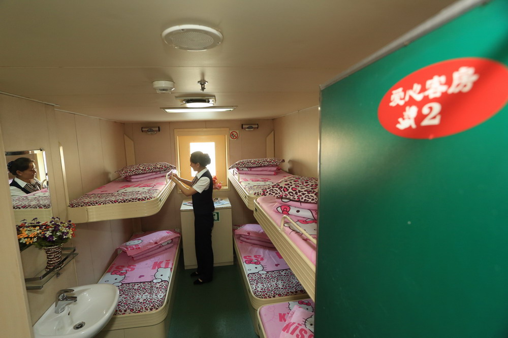 7月14日，在烟大线“葫芦岛”号客轮，一名服务人员在整理“女士专用舱”床铺。 
