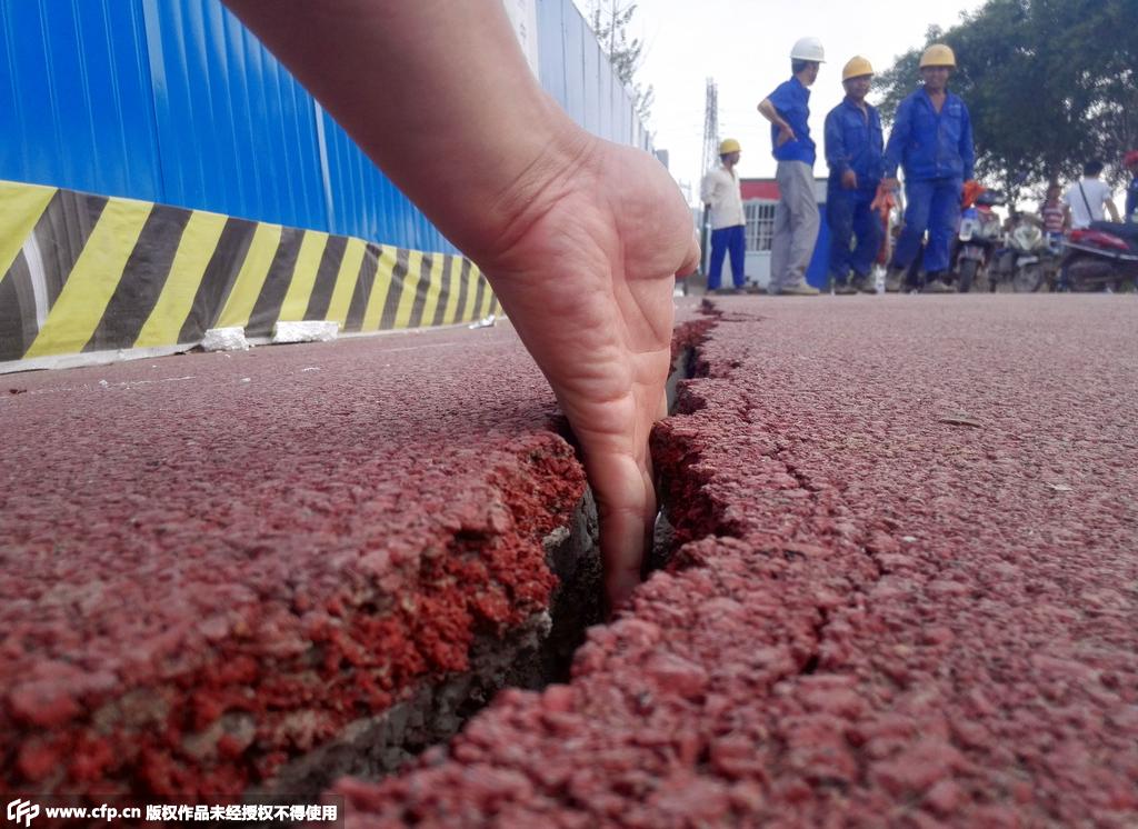 2015年7月20日，河南郑州，西三环与化工路交叉口东北角生态廊道内的人行道出现20多米长的裂缝。/CFP