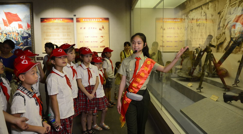 7月31日,小讲解员(右一)为前来参观的小学生们进行讲解.