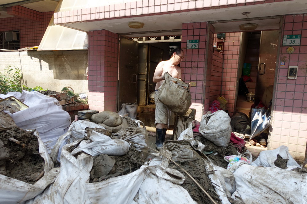 8月12日，乌来老街居民在清理家园。  
