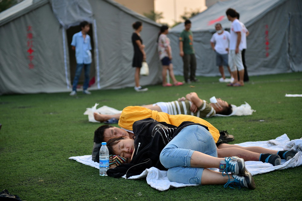 8月13日，周边居民在天津开发区第二小学操场休息。  