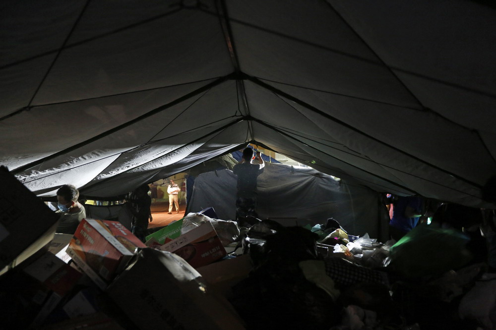 8月13日晚,在天津滨海新区开发区第二小学安置点,志愿者在搭帐篷,供