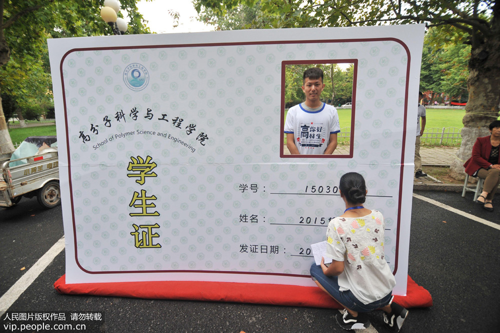 9月5日，入学新生在“巨型”学生证前拍照留念。（人民图片/王海滨）