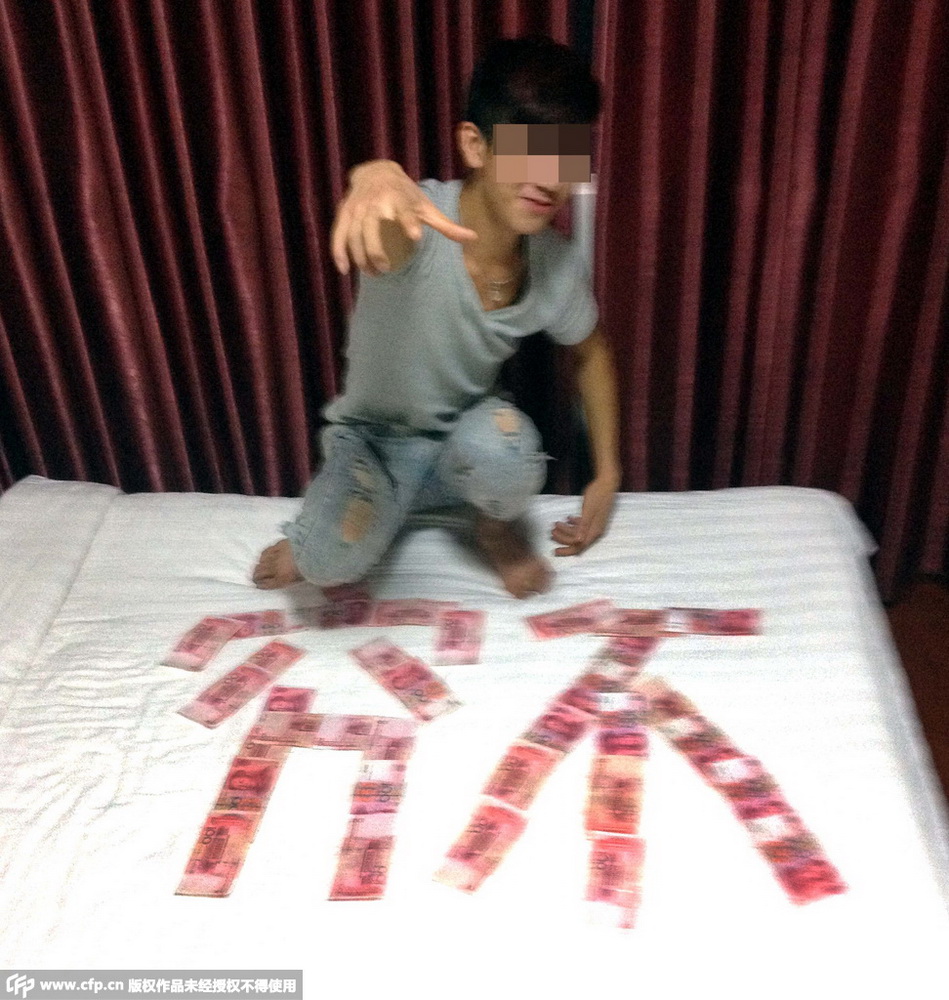 唐某在居住的旅店内把百元大钞尽情的“秀”了一把。/CFP