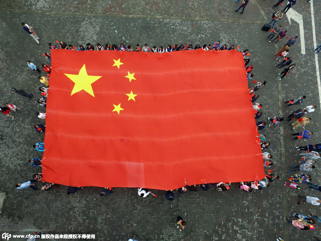 重庆市民与200平米巨型国旗合影，迎新中国66周年华诞。