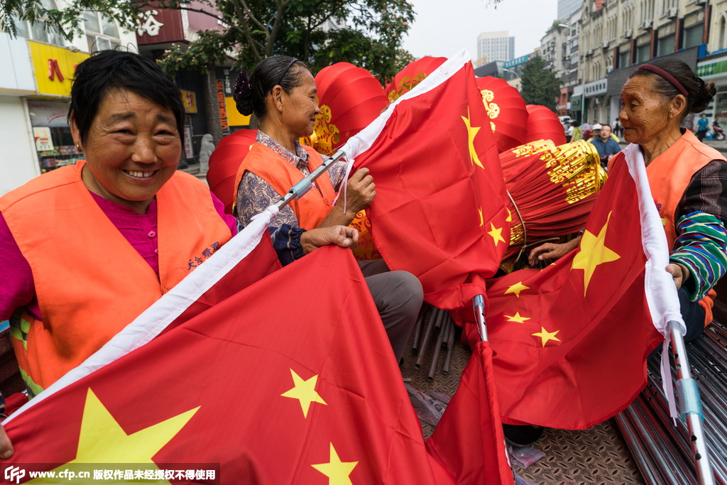 江苏无锡工人挂国旗灯笼，迎新中国66周年华诞。
