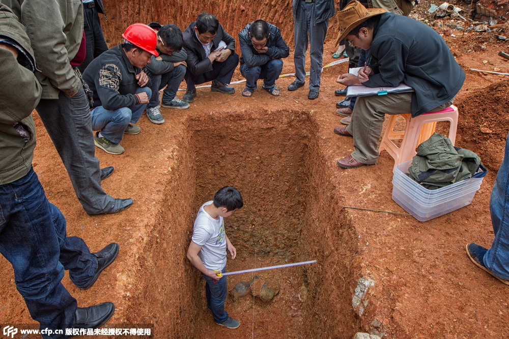 考古人员在7号墓挖掘出壶,鼎,敦各一个,引来附近工人和市民的围观