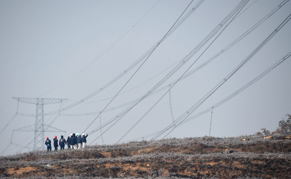  11月9日，电力工作人员在辽宁瓦房店瓦红线高压线塔下勘察受损现场。
