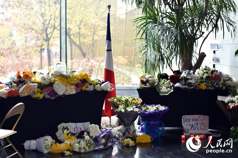 法国驻华使馆吊唁处摆满了鲜花和蜡烛。