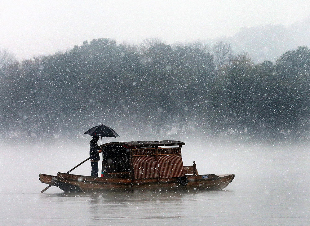 2015年12月5日，杭州降下2015年入冬第一场雪。西湖的水面上飘起层层白雾。(浙报集团 林云龙/视觉中国)