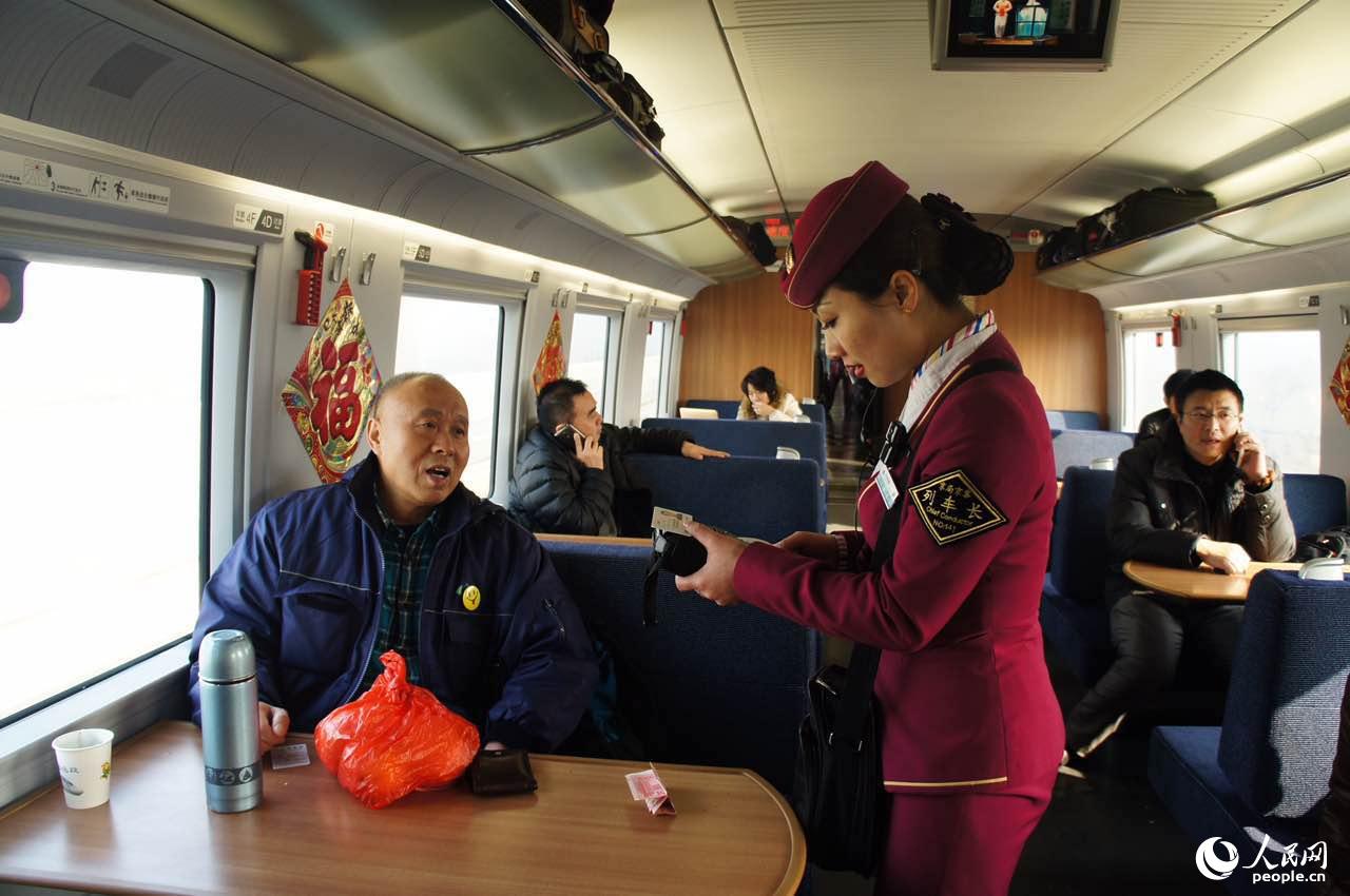 2月2日,京沪高铁G103列车长陈丽娟正在为乘客