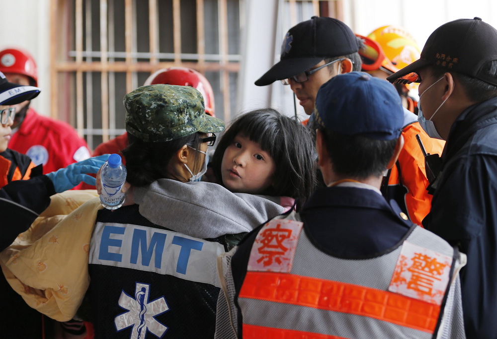 图为一个被救出的小女孩在救援人员怀中，神情有些恍惚。   