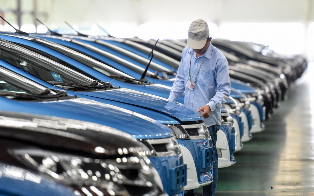 在位于深圳坪山新区的比亚迪总部工厂,工人检查装配好的比亚迪e6纯