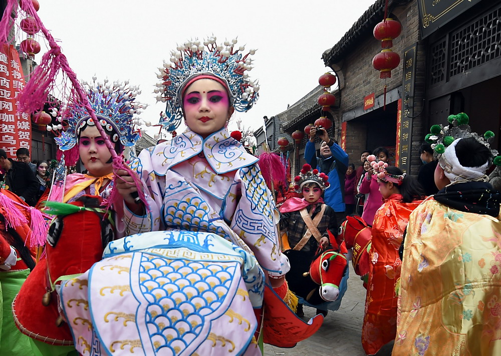 3月6日,几名小演员在河南滑县道口镇举行的古庙会上表演.