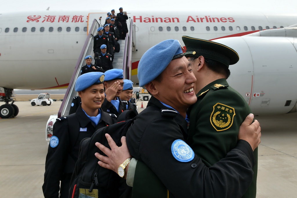 3月12日，维和警察防暴队员和前来欢迎的战友热烈拥抱。新华社记者朱峥摄