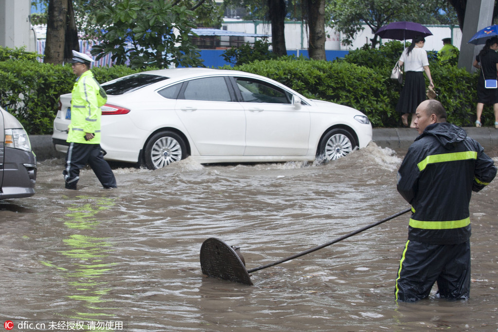 广州遭遇大雨市区多处被淹 市民卷裤管过河