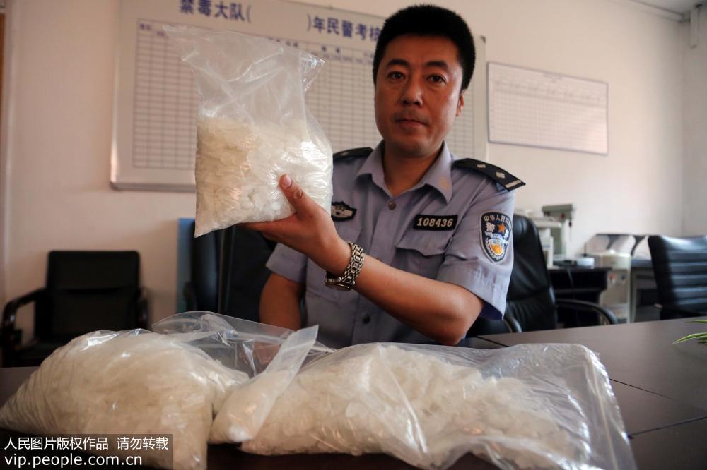 6月12日，沈阳市公安局铁西分局办案民警在展示缴获的毒品。