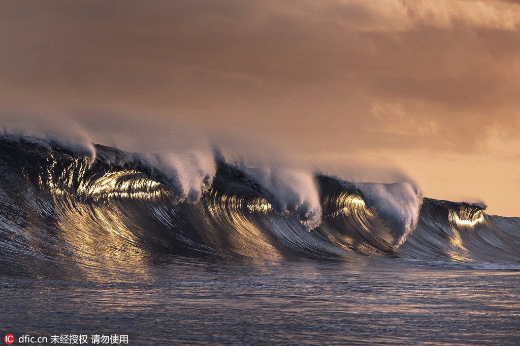 摄影师塔希提岛拍摄落日下的巨浪 金光灿灿令人迷醉