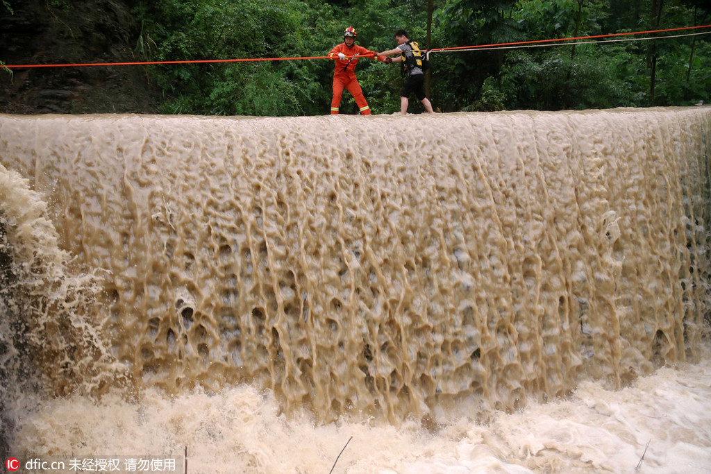 重庆:山洪暴发游客被困景区 消防架绳索成功救