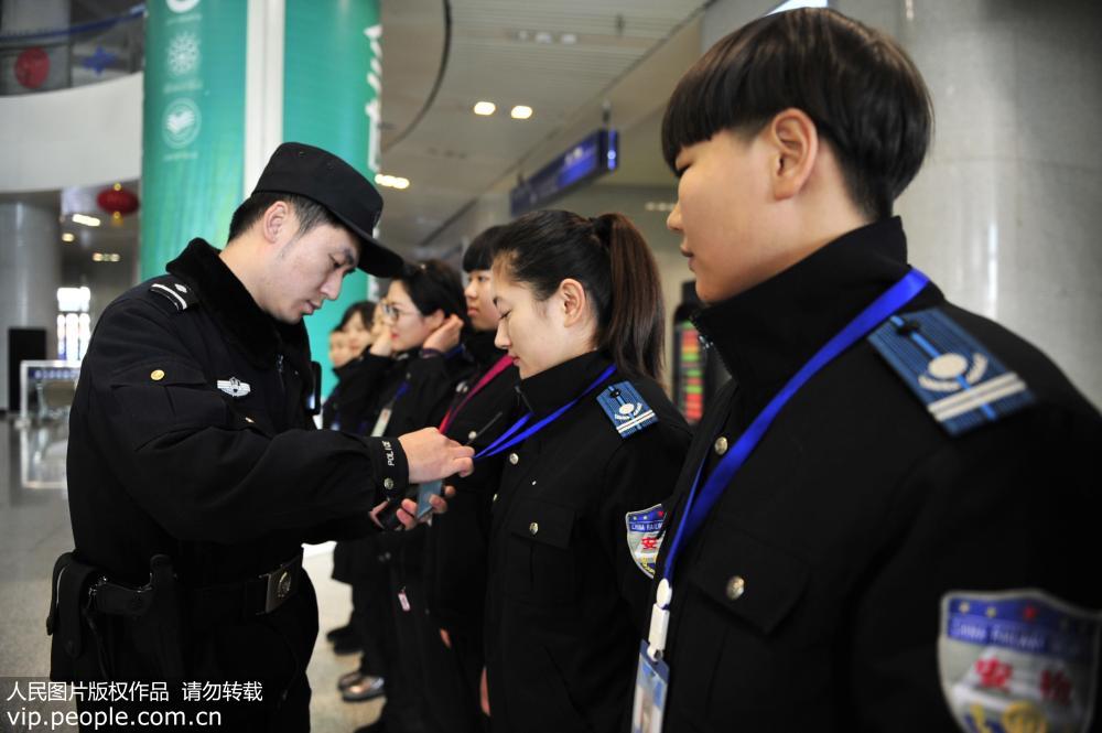 2017年1月16日，內蒙古呼和浩特火車站，安檢員李夢潔與同事一起在聽站內民警講解當日工作安排。