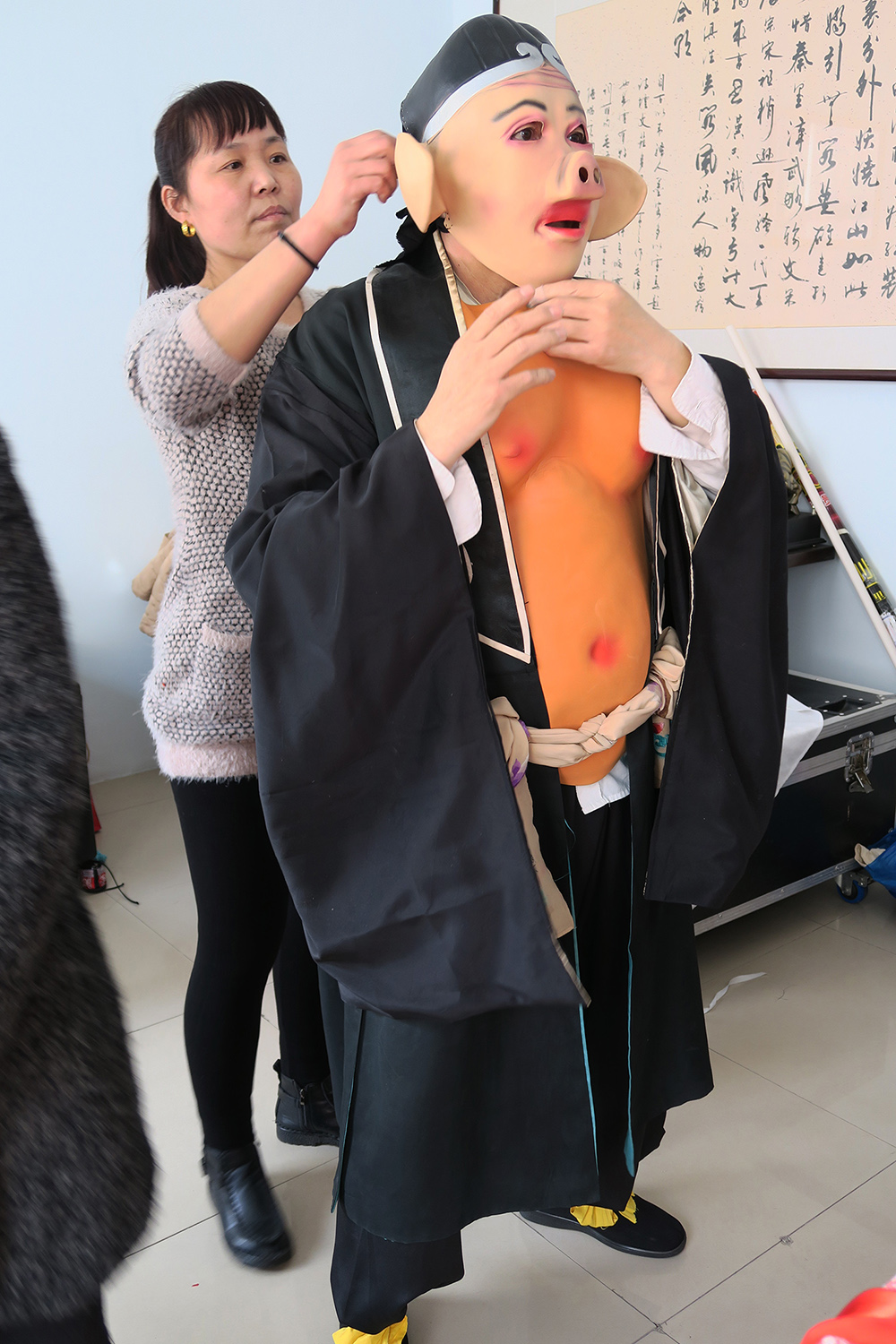 2月20日，扮演豬八戒的漁鼓戲演員在排演大型漁鼓戲《西游記—高老庄》之前穿上戲裝。
