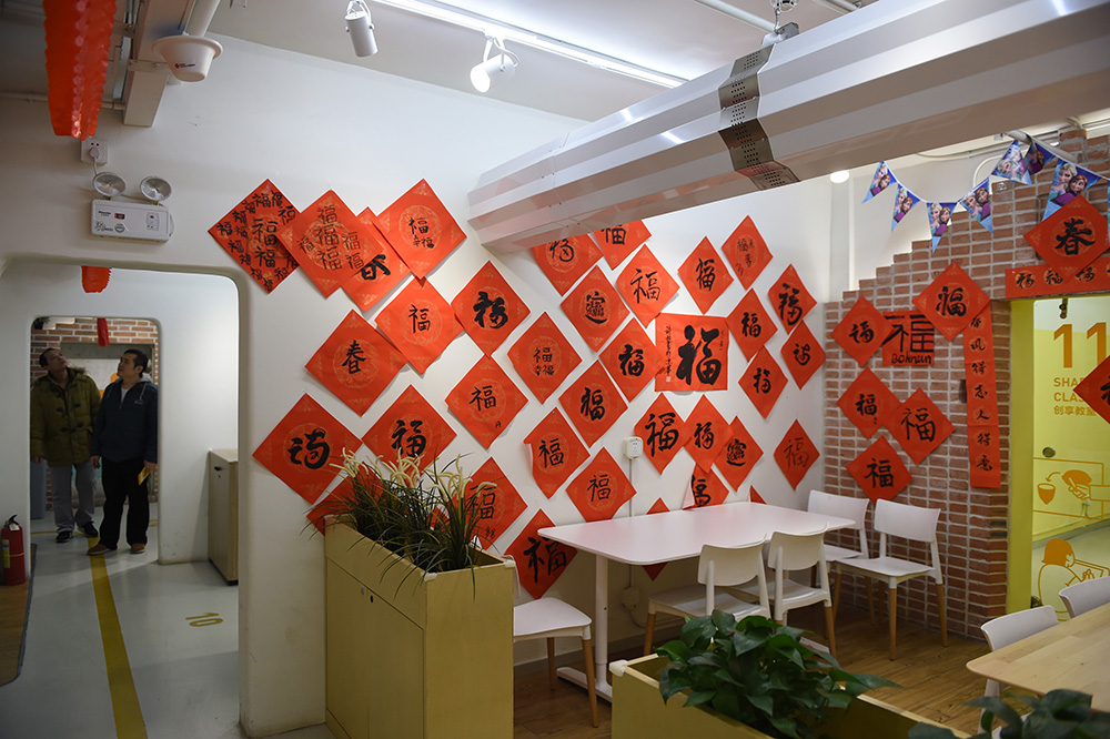 2月15日，幾位參觀者在“地瓜社區”參觀。牆上的“福”字來自“地瓜社區”小年夜的活動，房間裡懸空的是通風管道。
