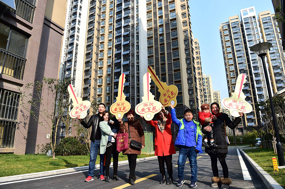 2月26日，回遷居民代表在小區裡拿著“鑰匙”模型，慶祝回遷。
