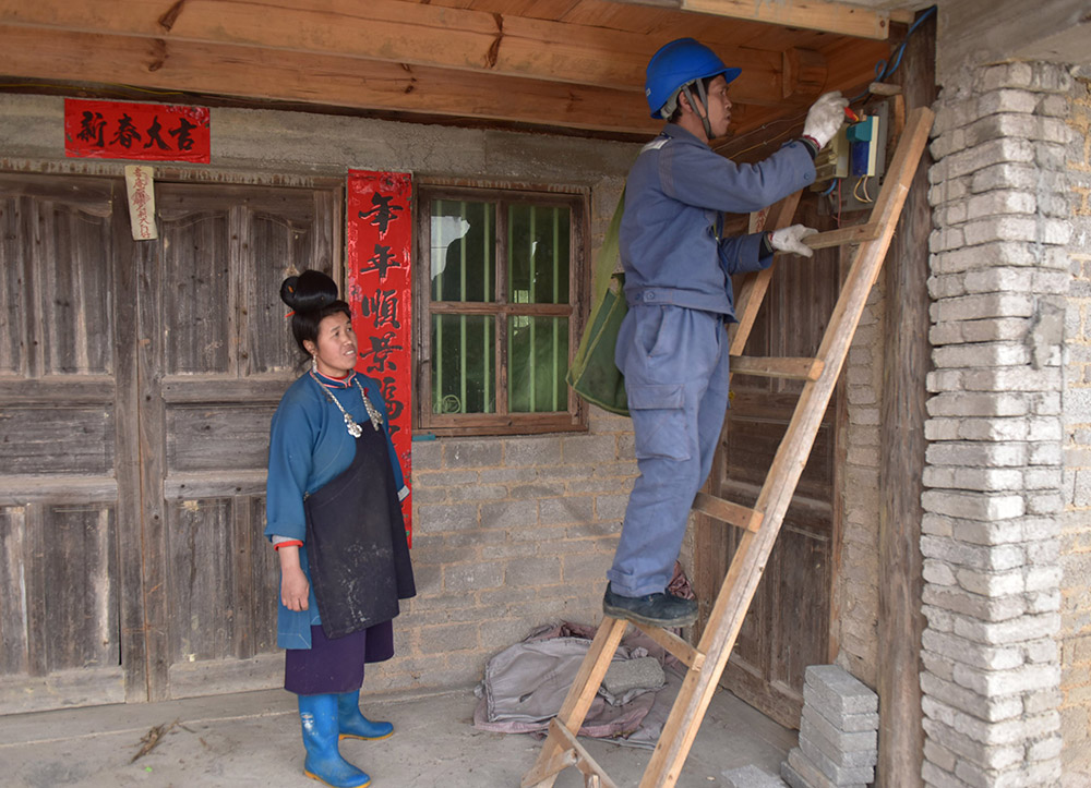 3月2日，貴州丹寨縣興仁供電所“雷鋒班”員工黃承林（右）在城望村村民潘朝芝家檢查電表。