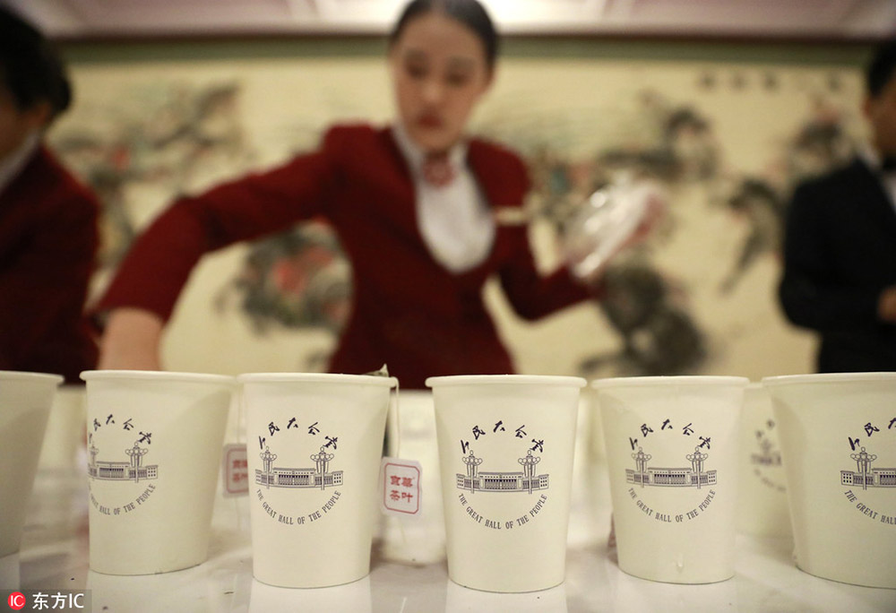 2017年3月5日，2017年全国两会在北京举行。人民大会堂，服务员一丝不苟整理水杯，给水杯里放茶叶。/东方IC