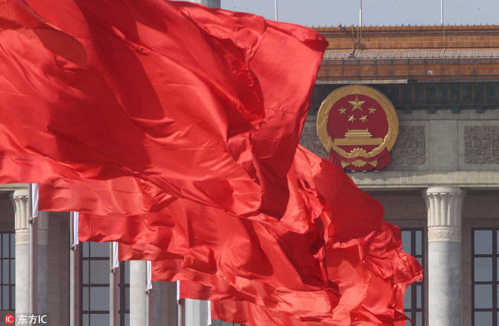 3月2日，在北京天安门广场，刚悬挂的红旗与人民大会堂的国徽遥相呼应。陈晓根/东方IC
