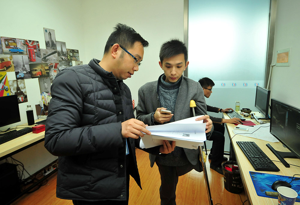 3月10日，在南昌中航長江設計師產業園，黎偉（前右）在工作室內和同事一起研究設計圖的效果。