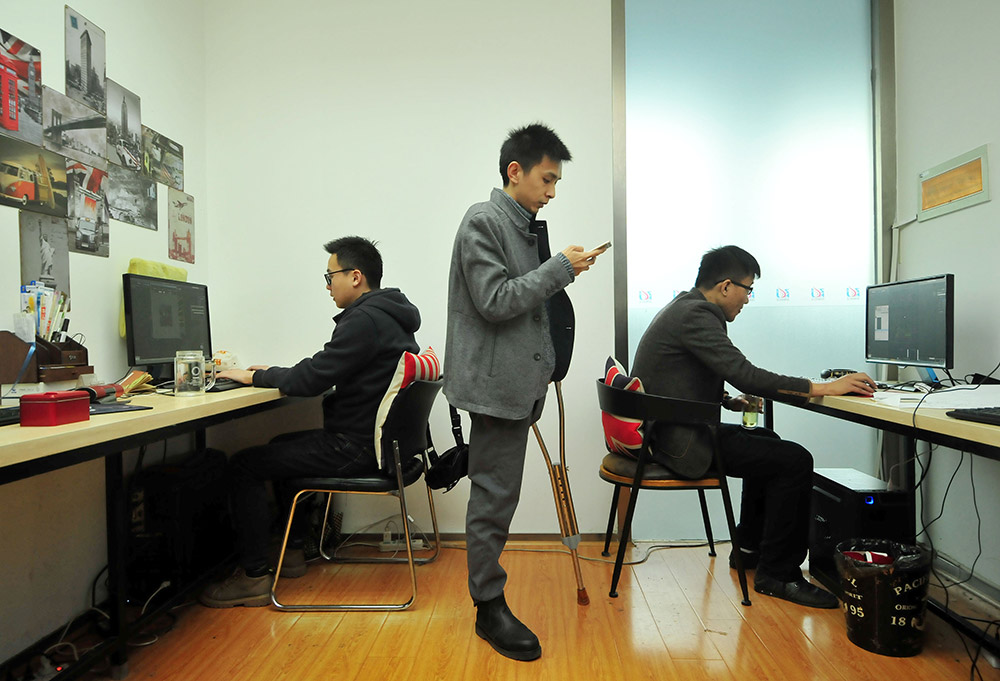3月10日，在南昌中航長江設計師產業園，黎偉（中）在工作室內和同事一起修改設計圖。