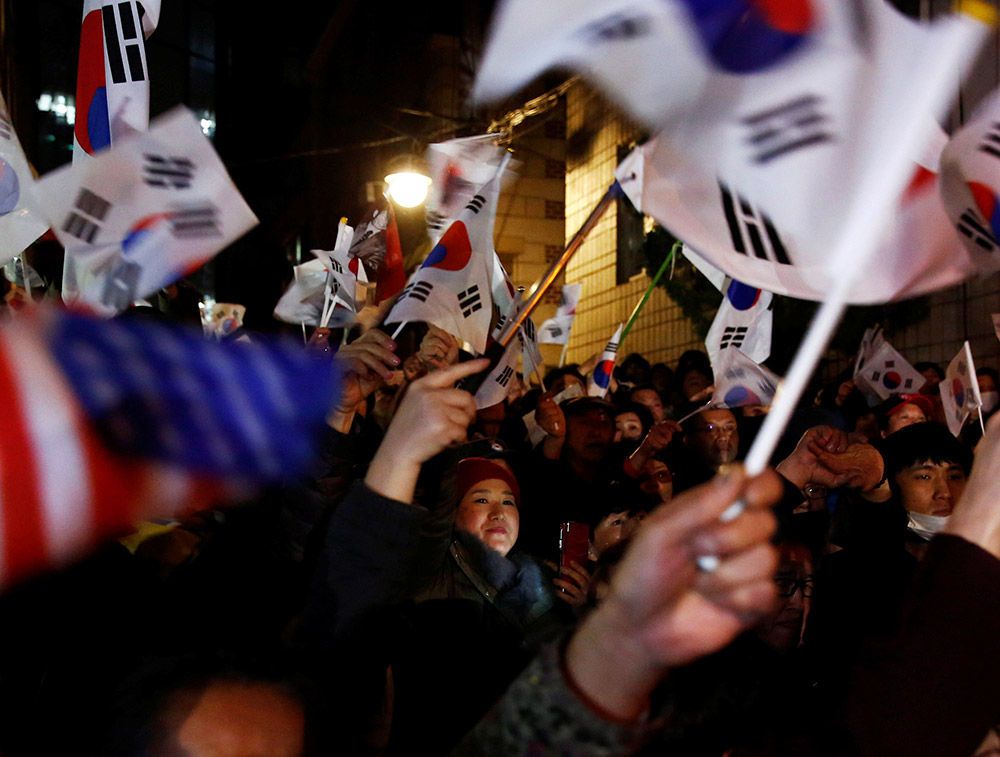 3月12日，支持者在位於韓國首爾三成洞的朴槿惠私邸外揮舞國旗。 新華社/路透