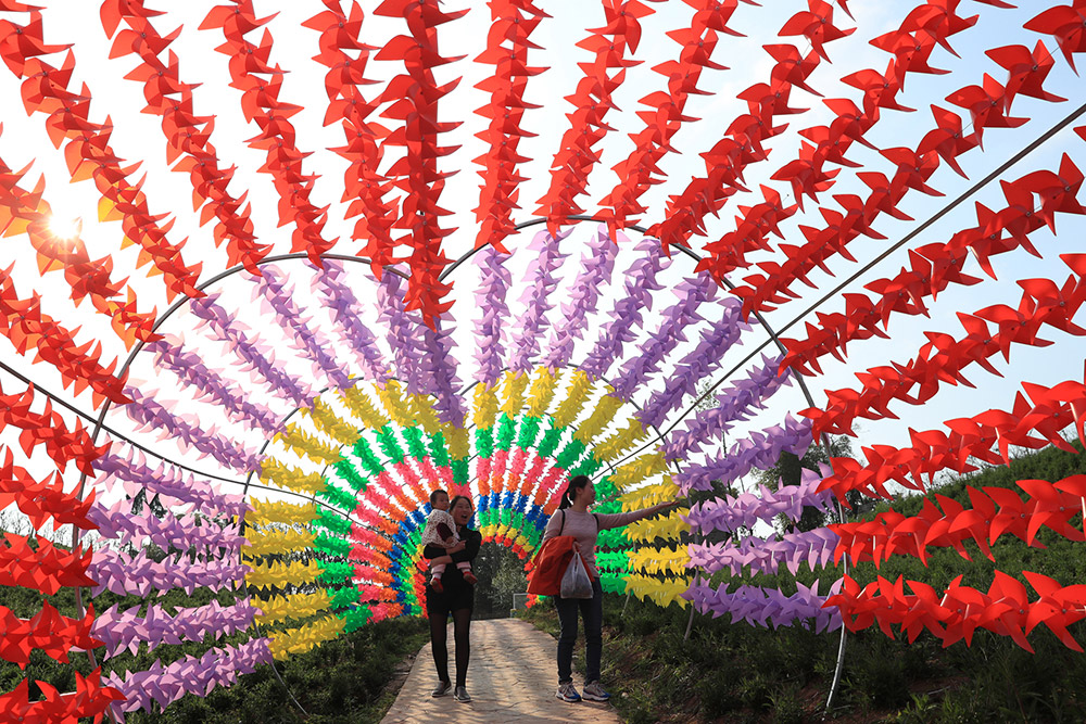 3月20日，游客在四川省華蓥市祿市鎮涼水井村參觀風車。