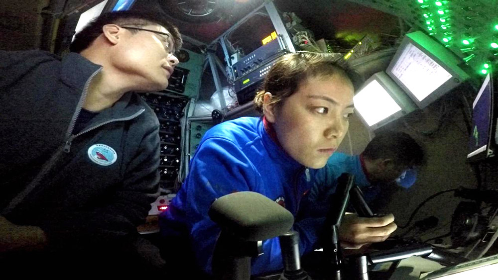 本航次主駕駛、實習潛航員趙晟婭（中）手持機械手操作杆准備採樣（3月19日攝）。